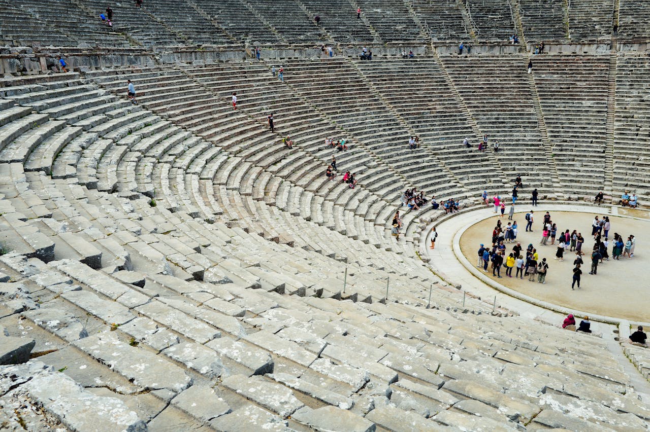Tourists explore the ancient amphitheater showcasing historic architecture and cultural heritage.