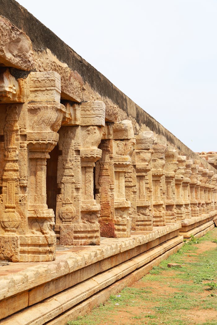 who-we-are Detailed view of ancient stone columns forming part of a historic Indian temple.